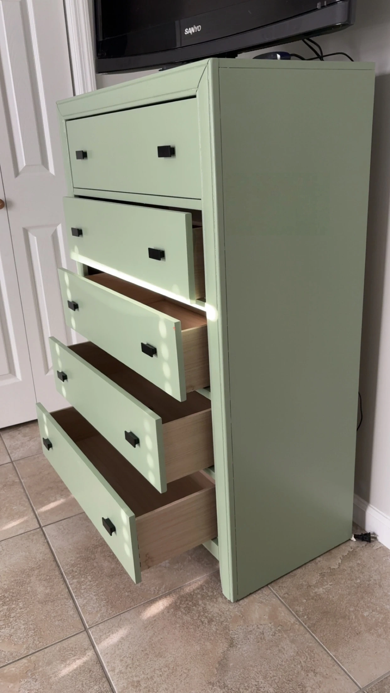 Restored 5-drawer dresser painted in matte sage green with modern black hardware