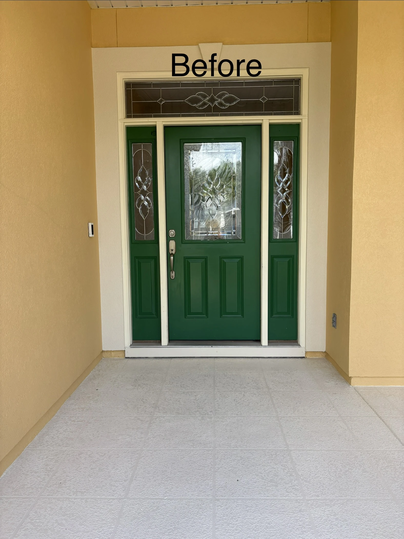 Covered entryway with dark forest green front door and sidelights before refinishing