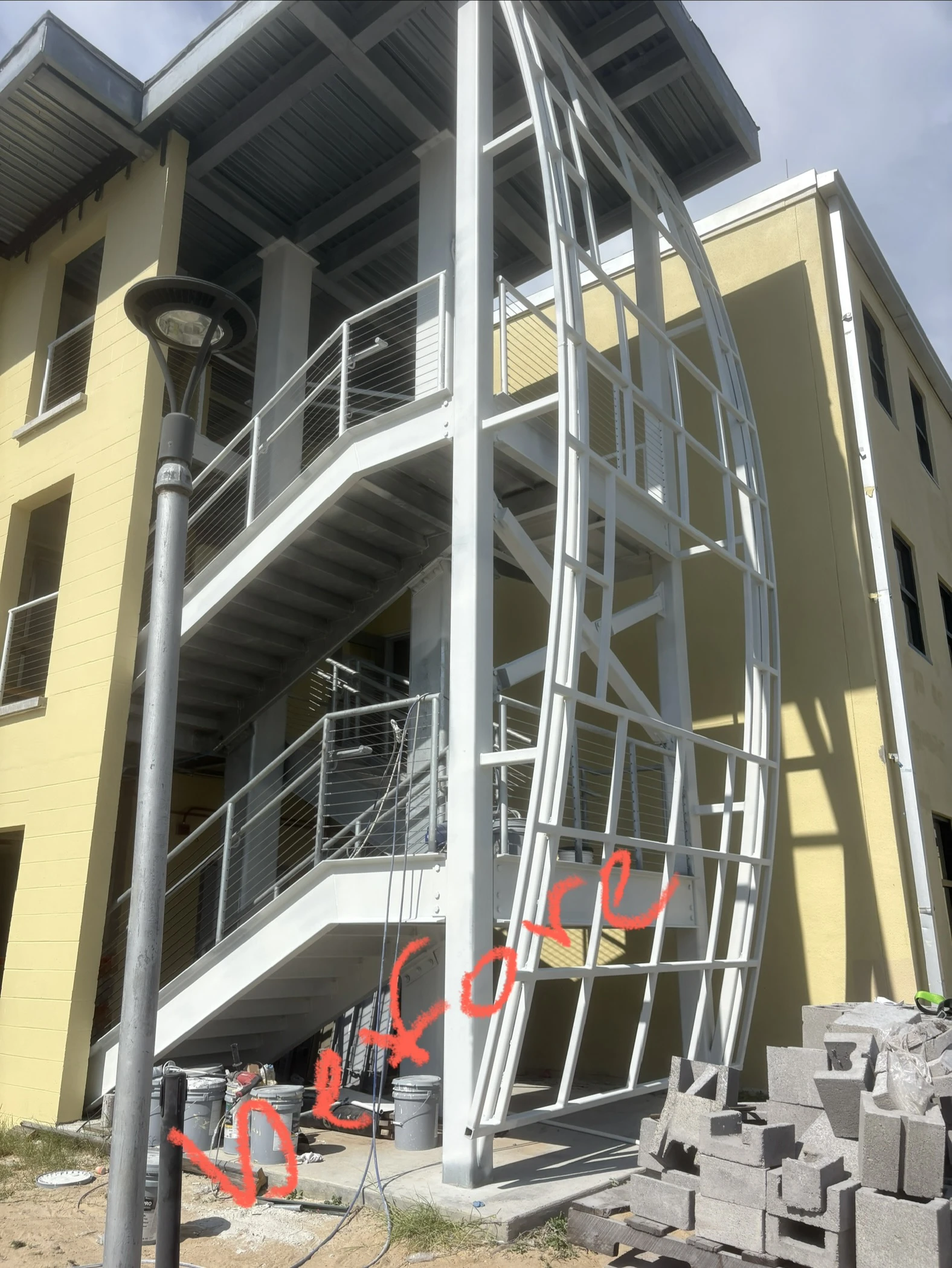 Commercial multistory curved staircase tower in primer white before coating