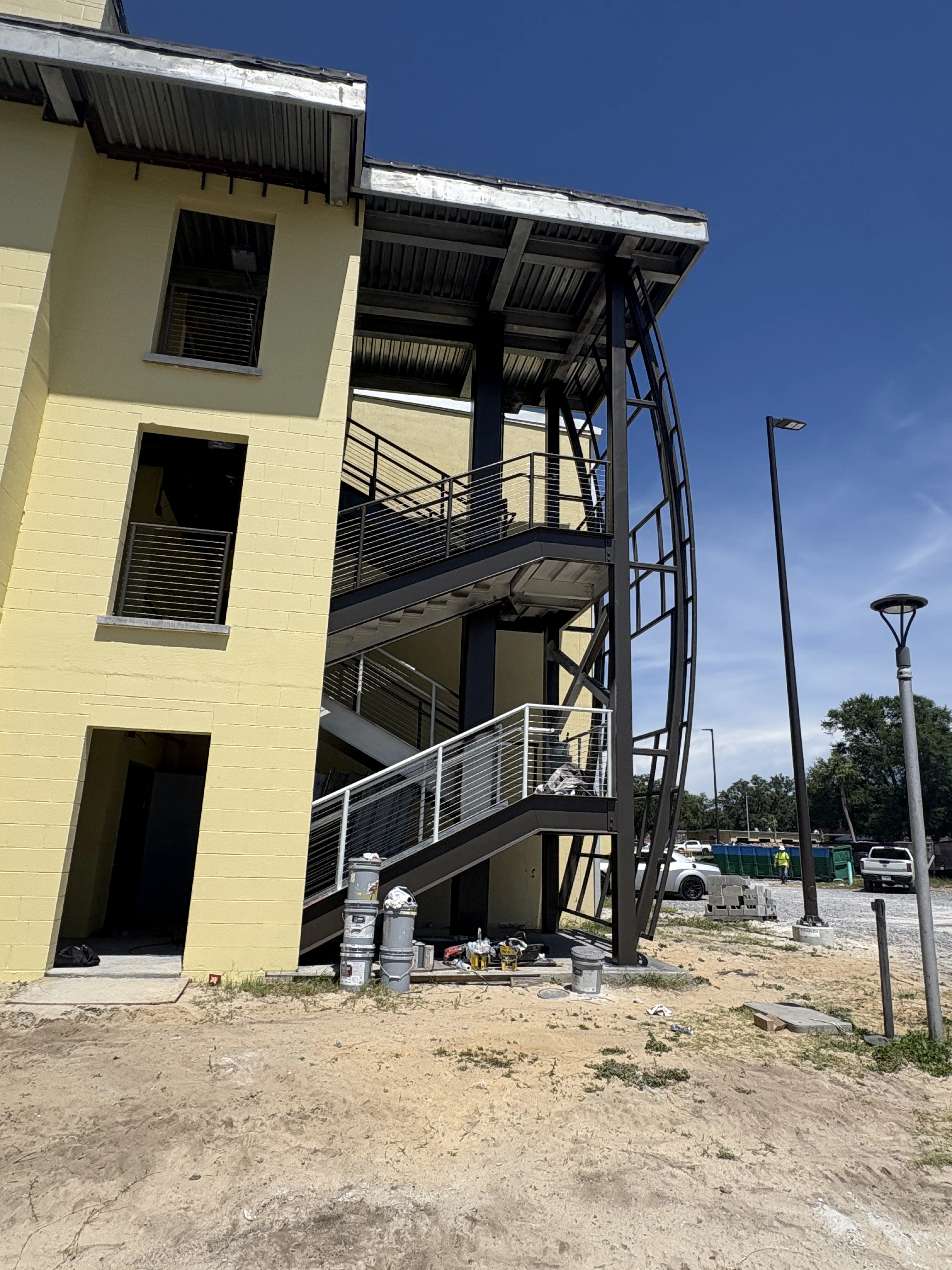 Commercial multistory exterior repaint and curved staircase tower coating by Scorpion Paint