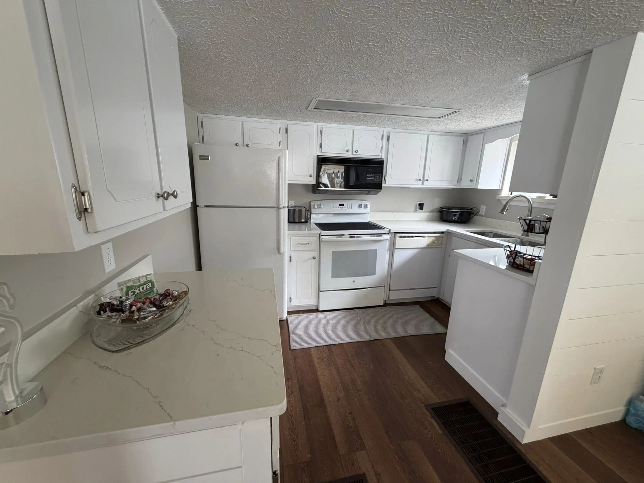 Kitchen cabinet transformation — pristine white satin finish with quartz countertops by Scorpion Paint