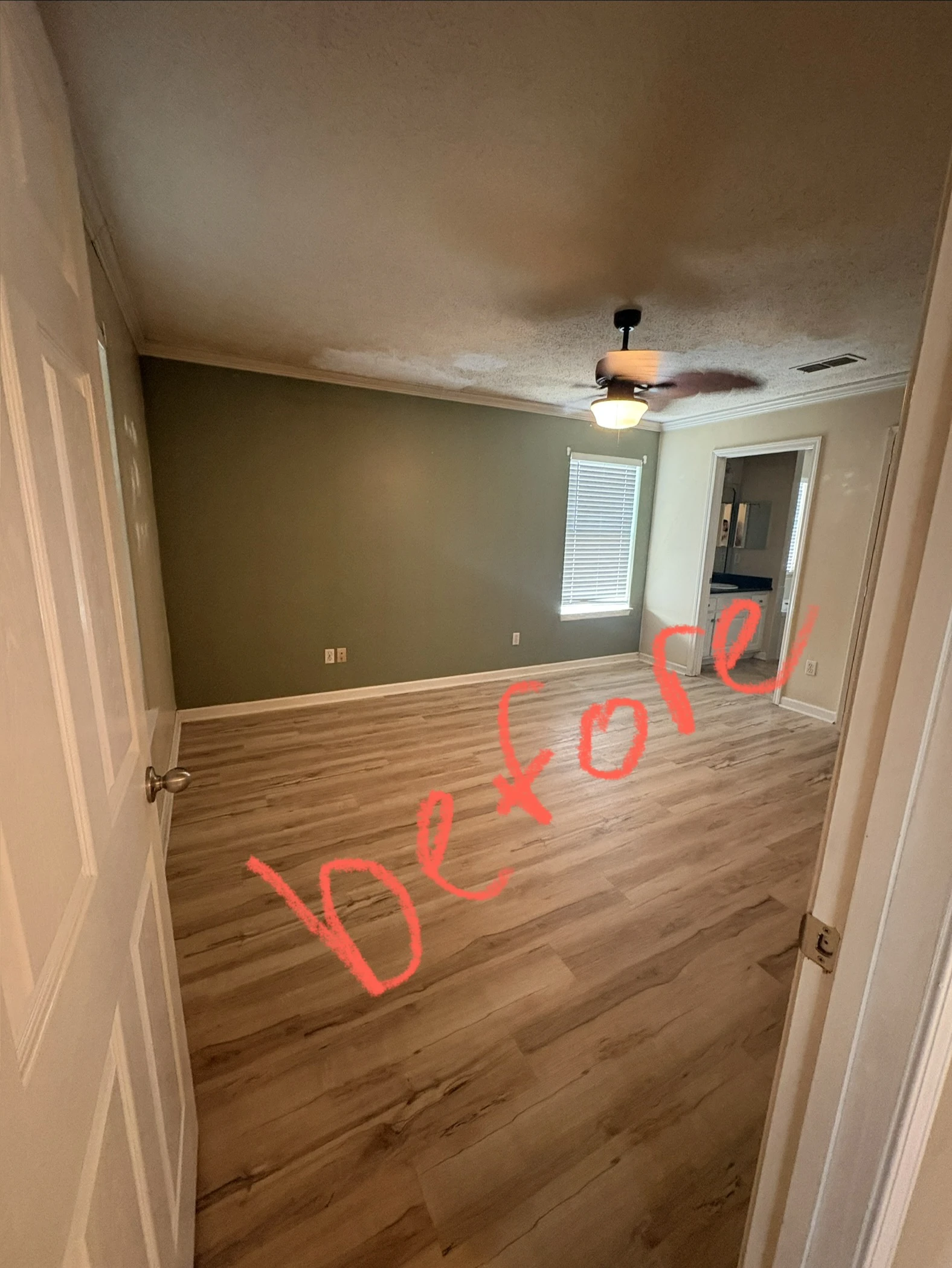 Primary bedroom with olive green accent wall before painting