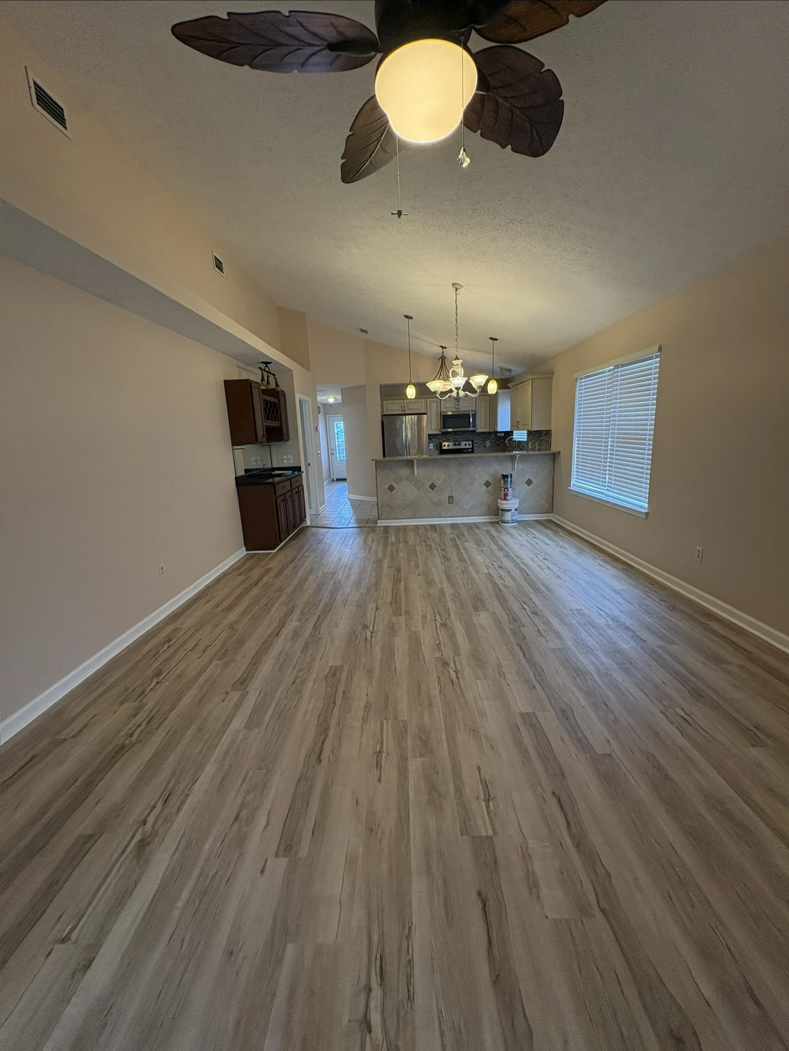 Open-concept great room and kitchen unified in warm neutral beige by Scorpion Paint