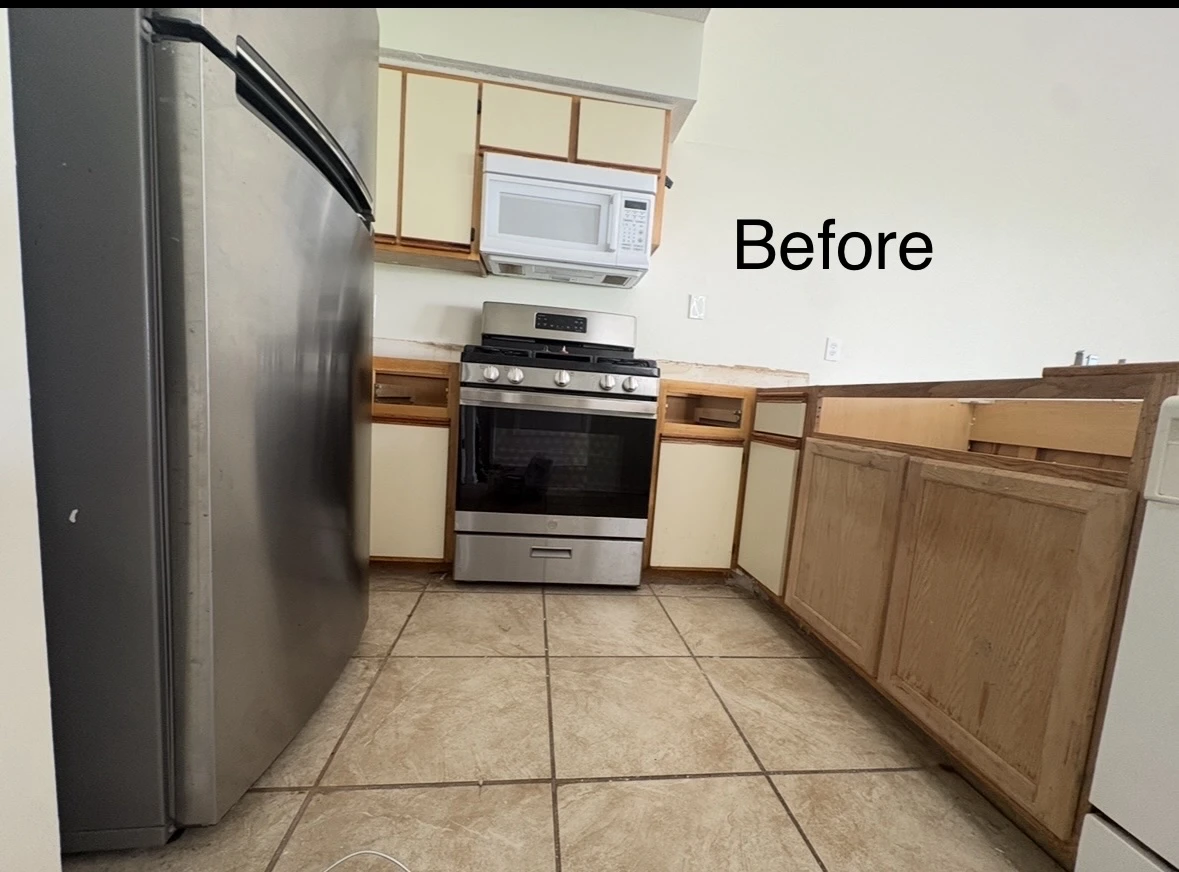 Kitchen cabinets during prep with mismatched wood lower and cream upper doors